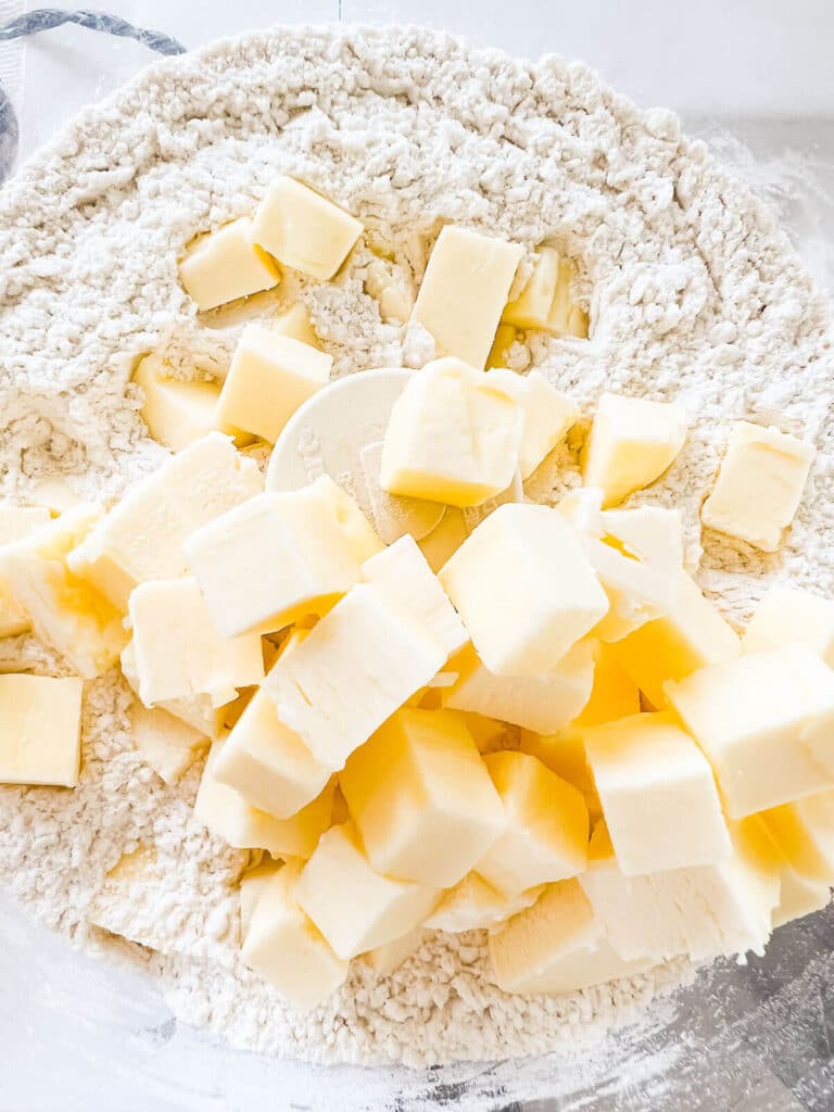 Cubes of cold butter over dry ingredients in food processor to make pie crust.