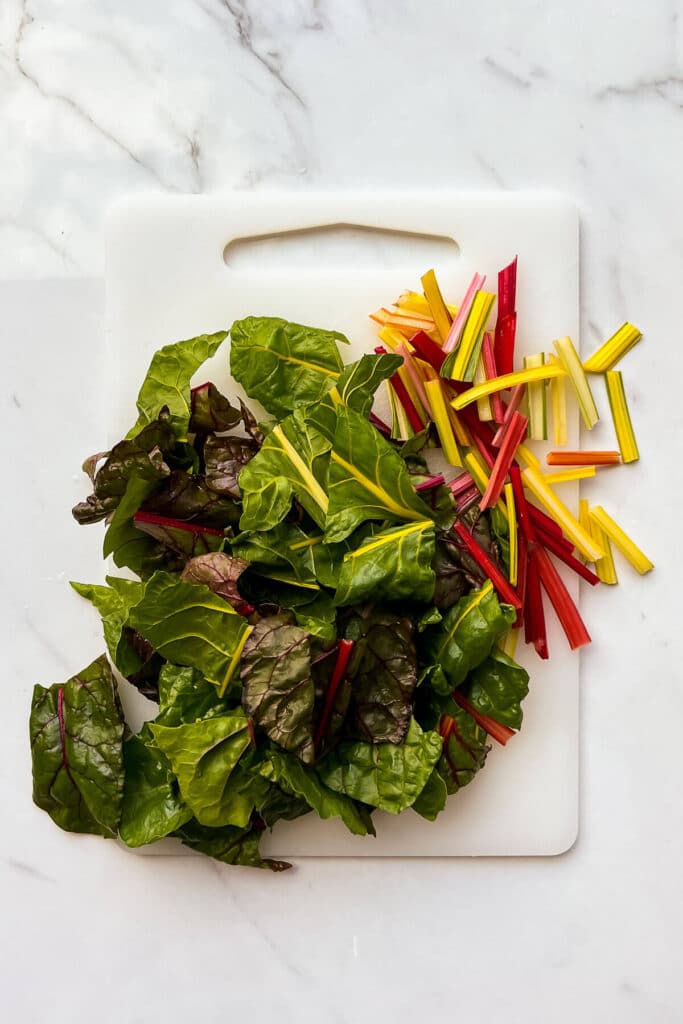 Chopping rainbow Swiss chard to make a quiche filling with it.