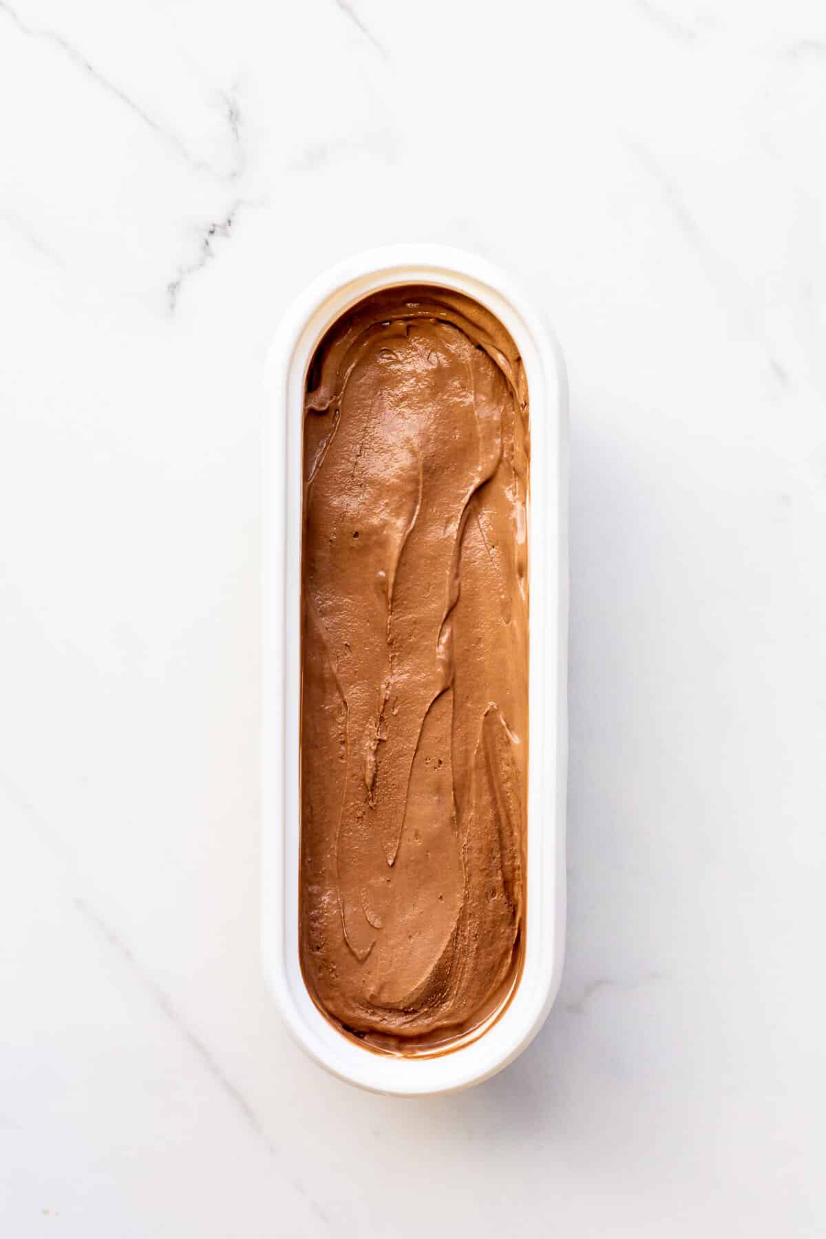 A tub of freshly churned homemade chocolate ice cream to be hardened in the freezer before scooping and serving.