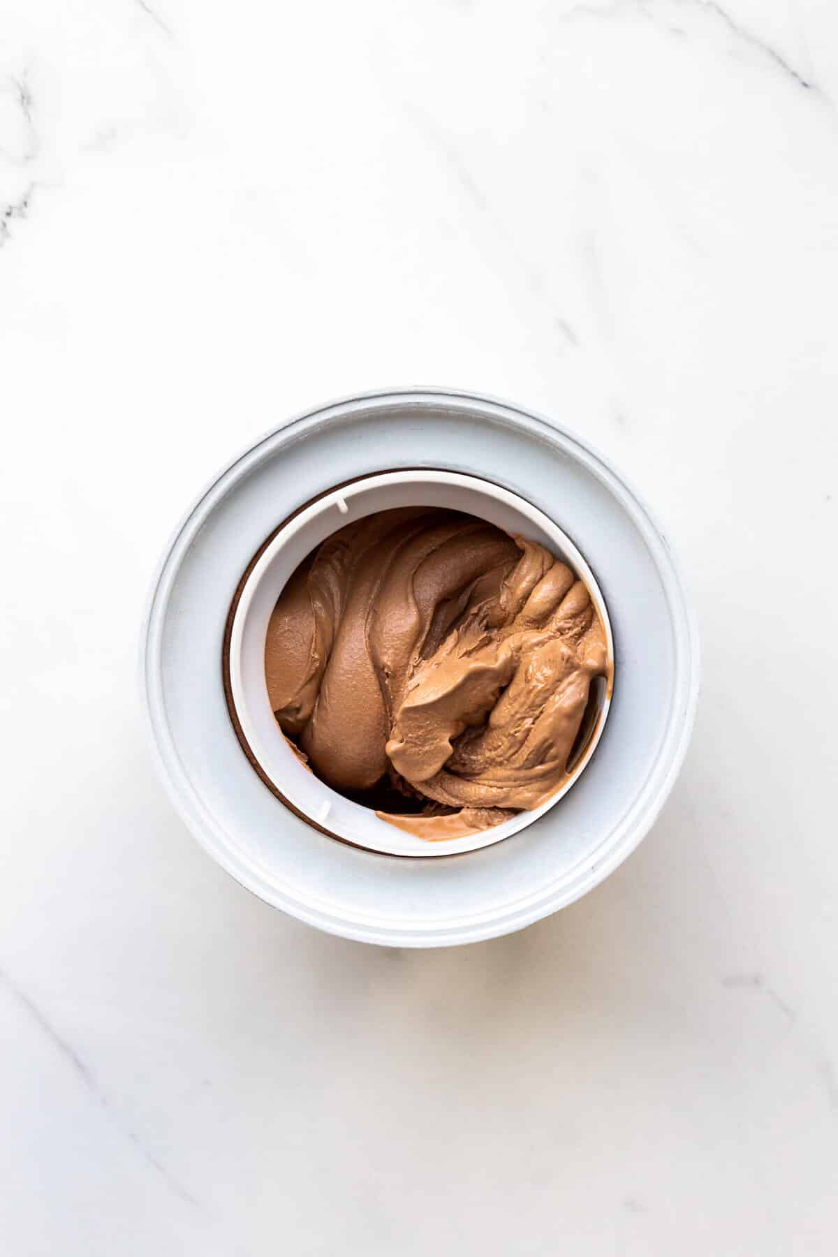 Freshly churned homemade chocolate ice cream with the texture of soft serve, ready to be hardened in the freezer before serving.