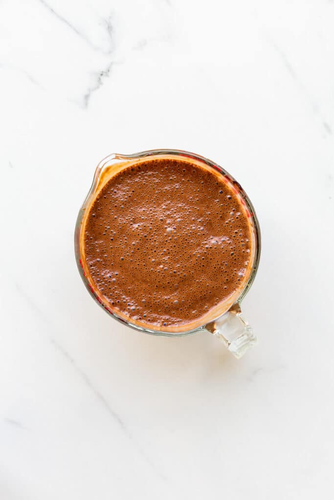 Dark chocolate crème anglaise in a measuring cup with a pouring spout so that it's easy to pour in an ice cream machine to churn it.