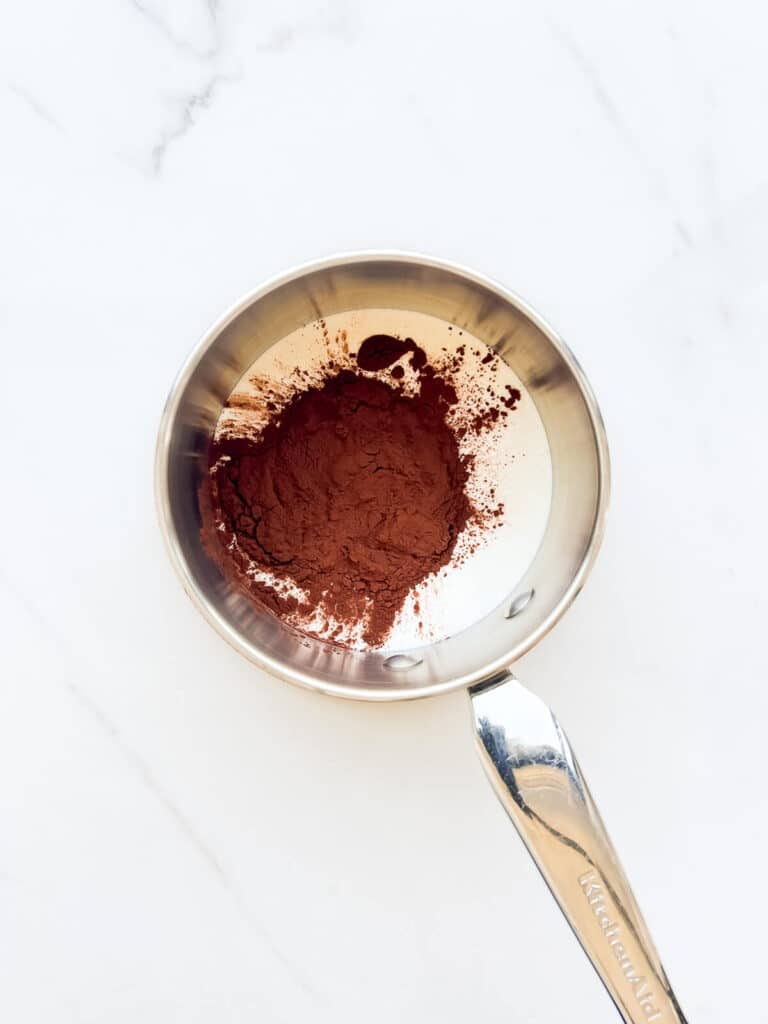 Cream and cocoa powder in a saucepan to be heated on the stove.