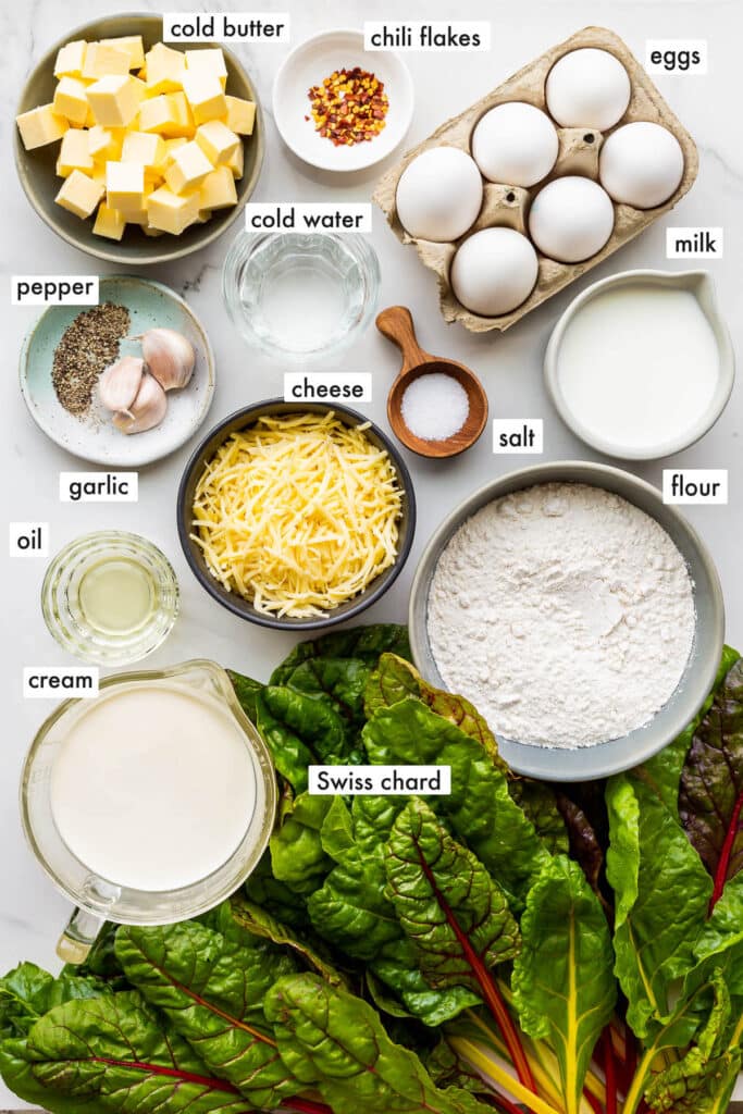 Ingredients to make a deep dish quiche with Rainbow Swiss chard and shredded cheese.