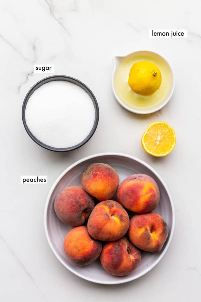 Ingredients to make peach jam, include just lemon juice, sugar, and peaches.
