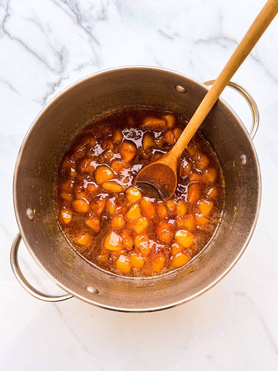 A pot of peach jam after boiling to the jam setting point on the stove.