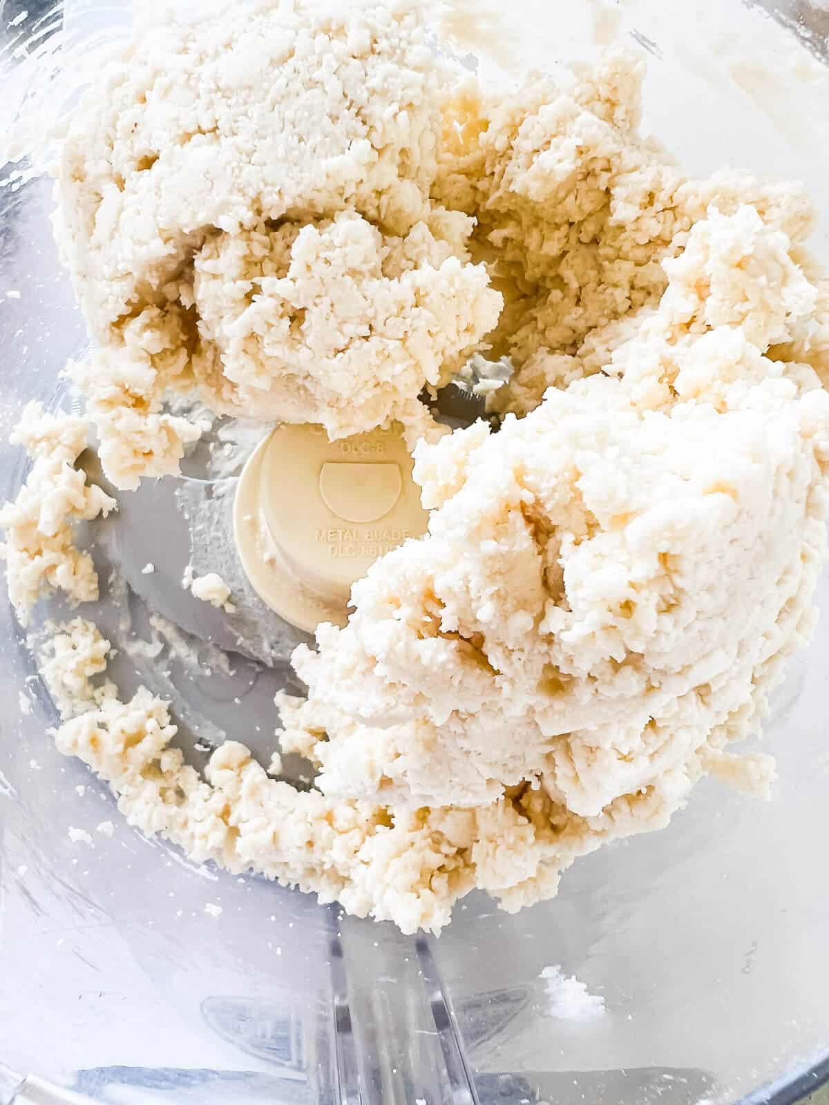 https://bakeschool.com/wp-content/uploads/2022/08/Pulse-in-water-to-make-pie-dough-in-food-processor.jpg