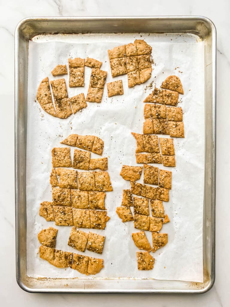 Freshly baked sourdough discard crackers on a sheet pan.