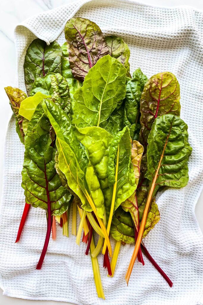 Washed rainbow Swiss chard on a towel to dry it for a quiche filling.