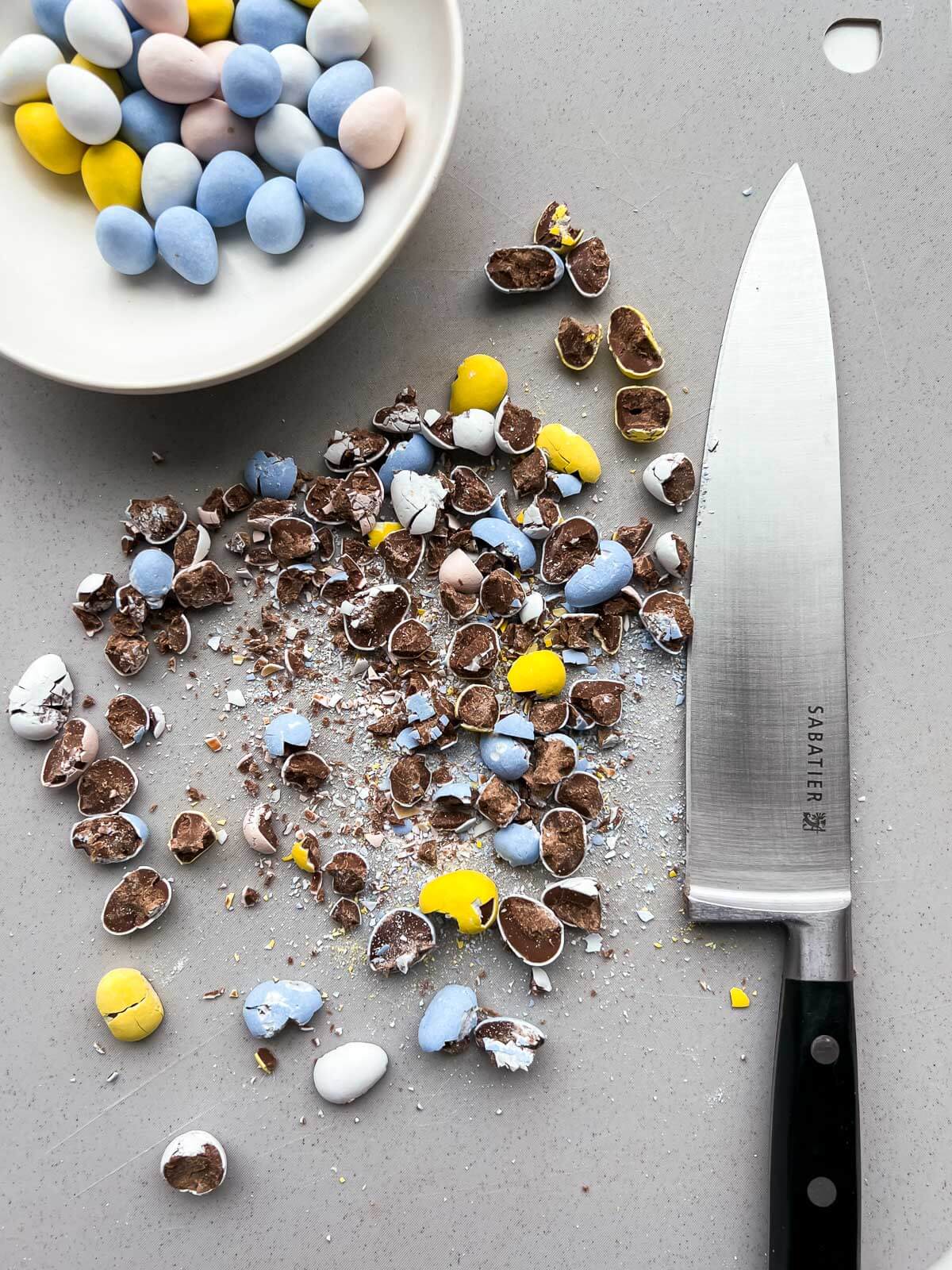 Chopping Cadbury Mini Eggs with a chef's knife to make Easter brownies.