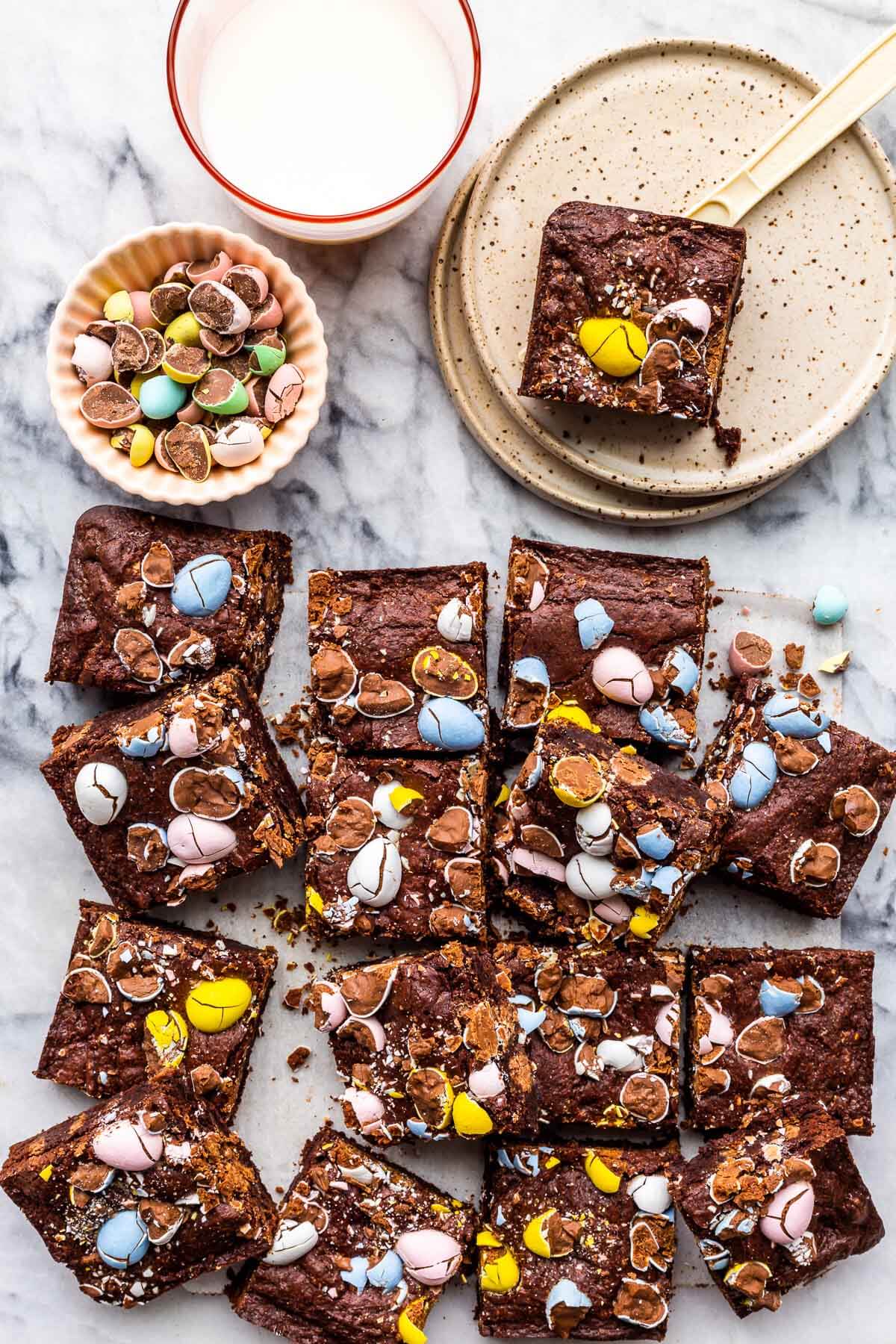 Easter brownies with Mini Eggs cut into squares to serve with a glass of milk.