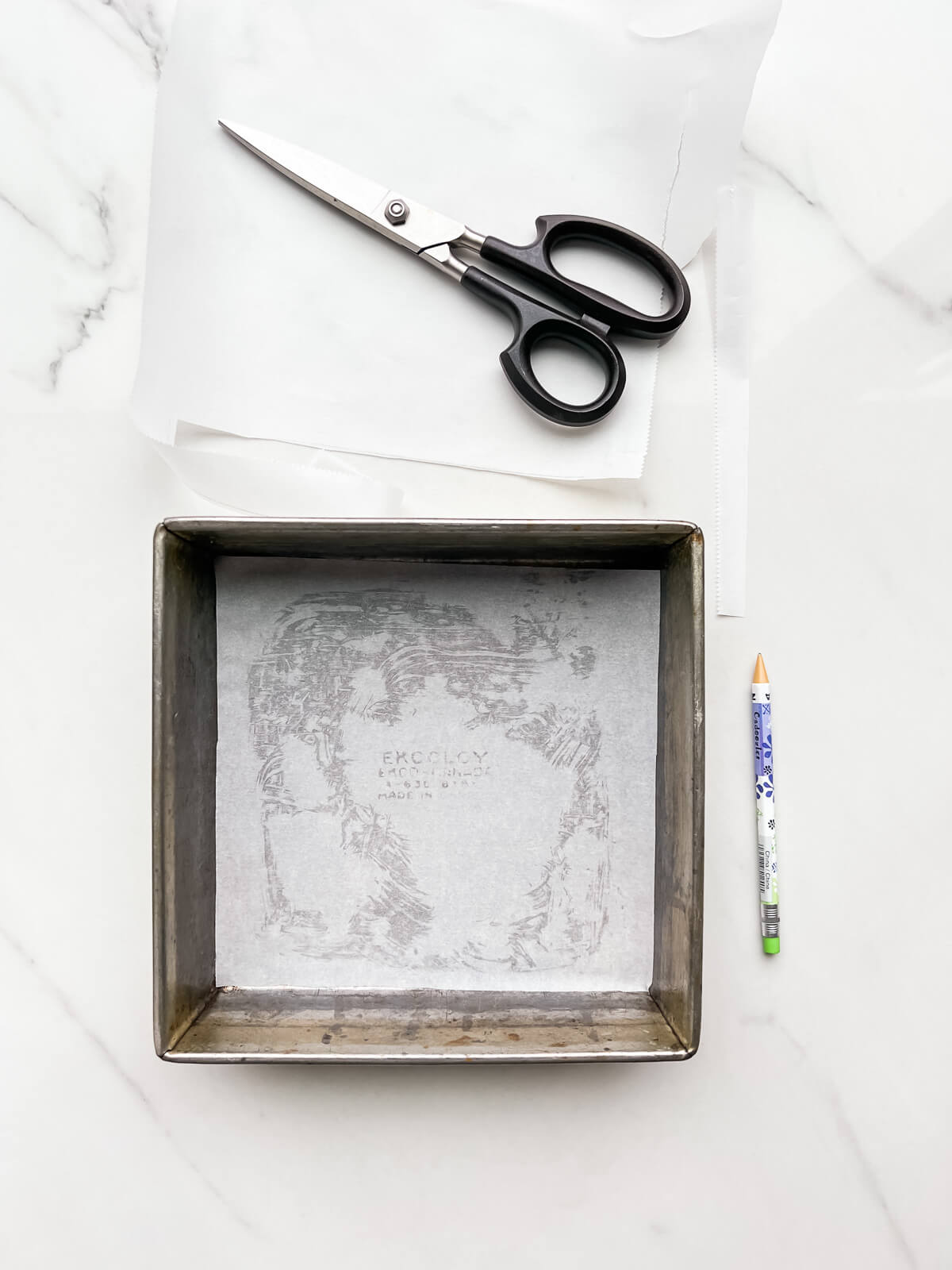 Lining the bottom of a brownie pan with a square of parchment to prevent baked goods from sticking.