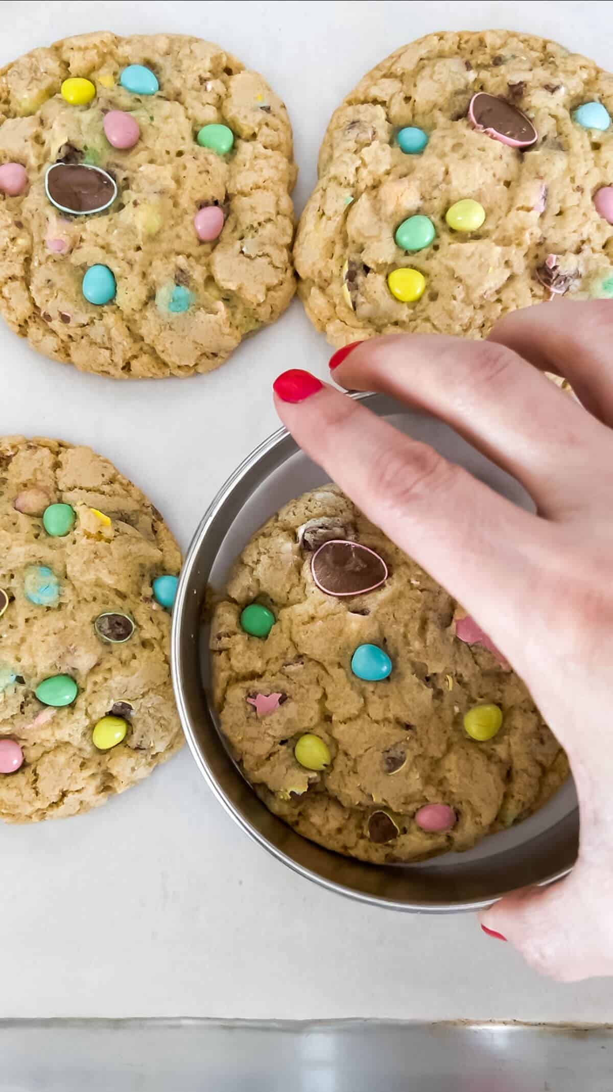 Using a large round cookie cutter to tighten the edges of a cookie that spread in the oven.