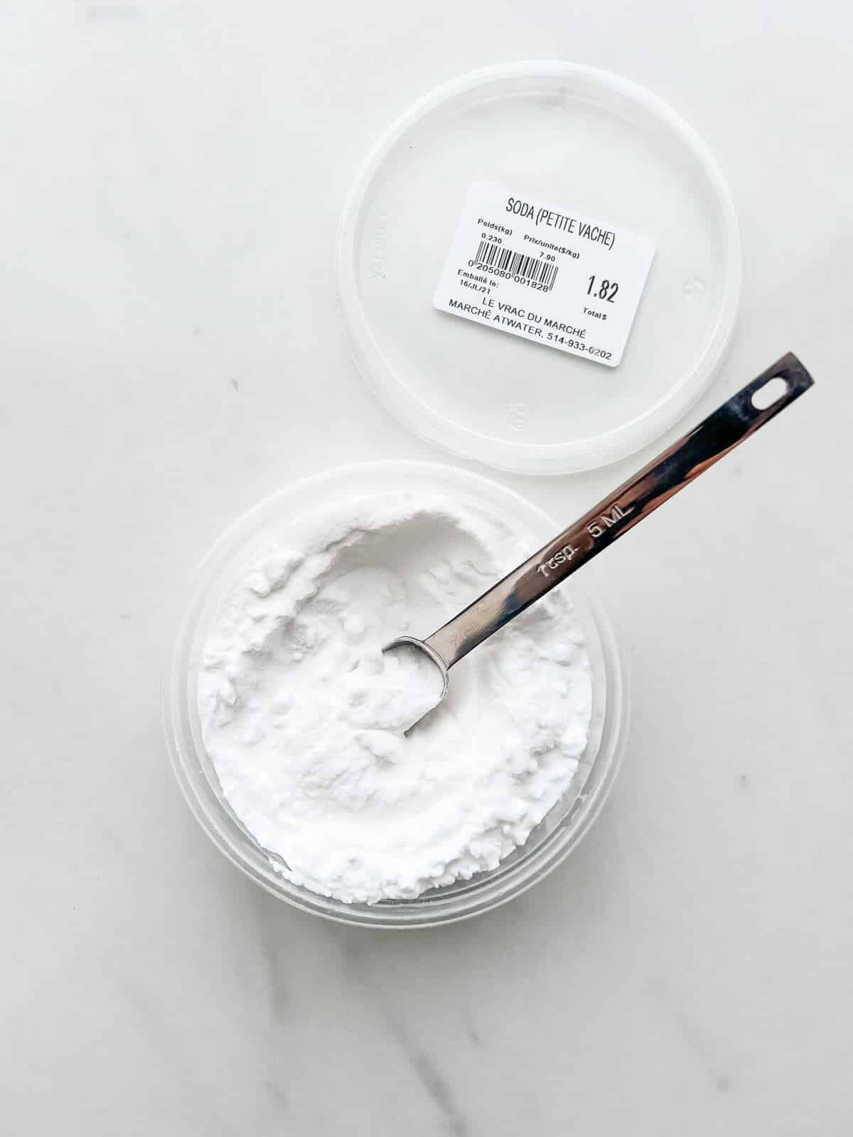 An open container of baking soda from the brand Petite Vache