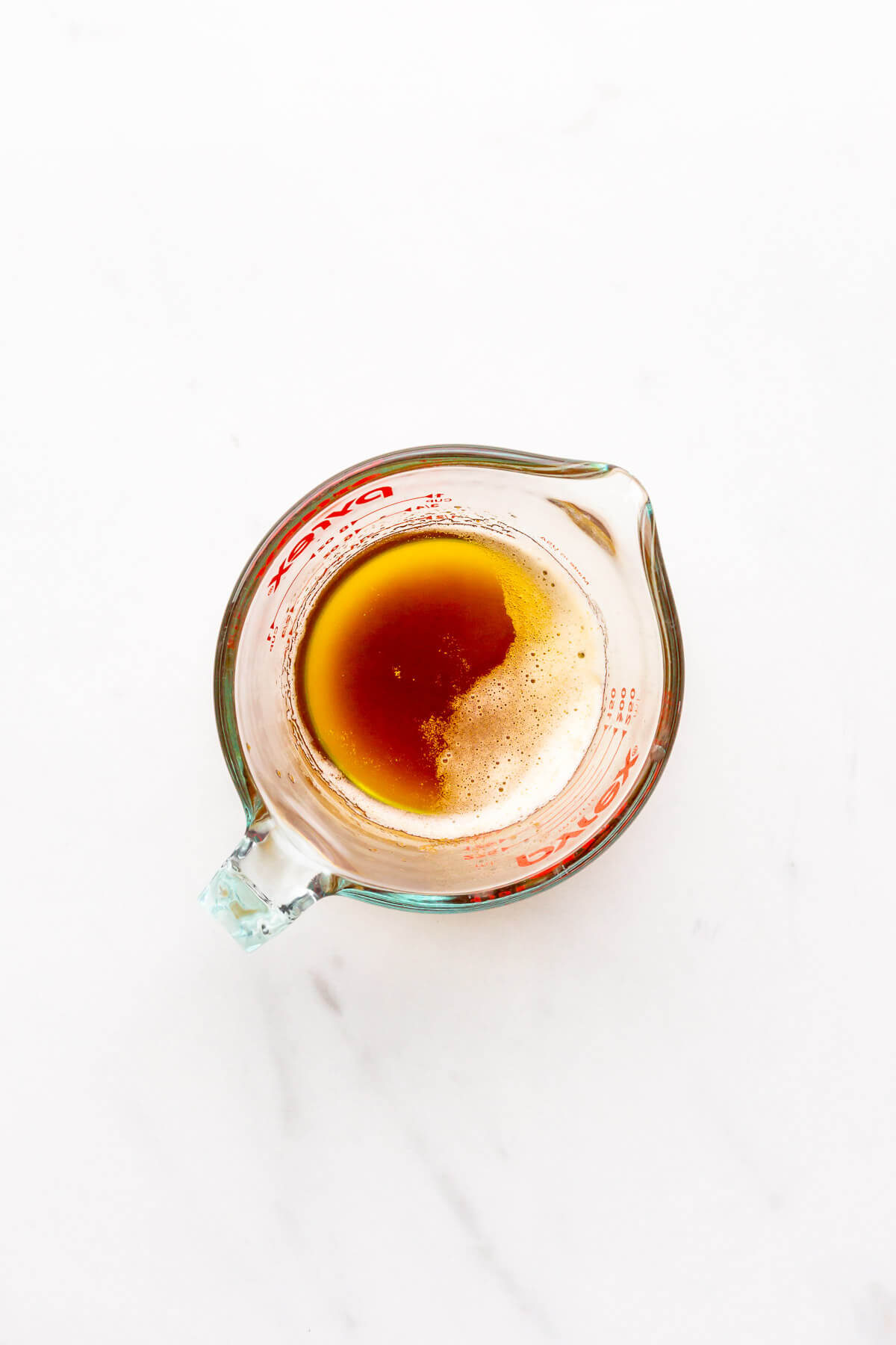 A glass measuring cup filled with brown butter.