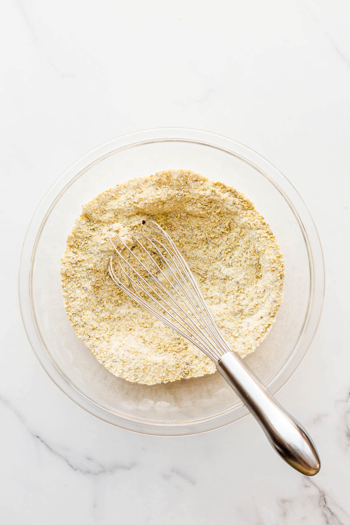 Whisking the dry ingredients (flour, sugar, and ground pistachio) to make financier batter.