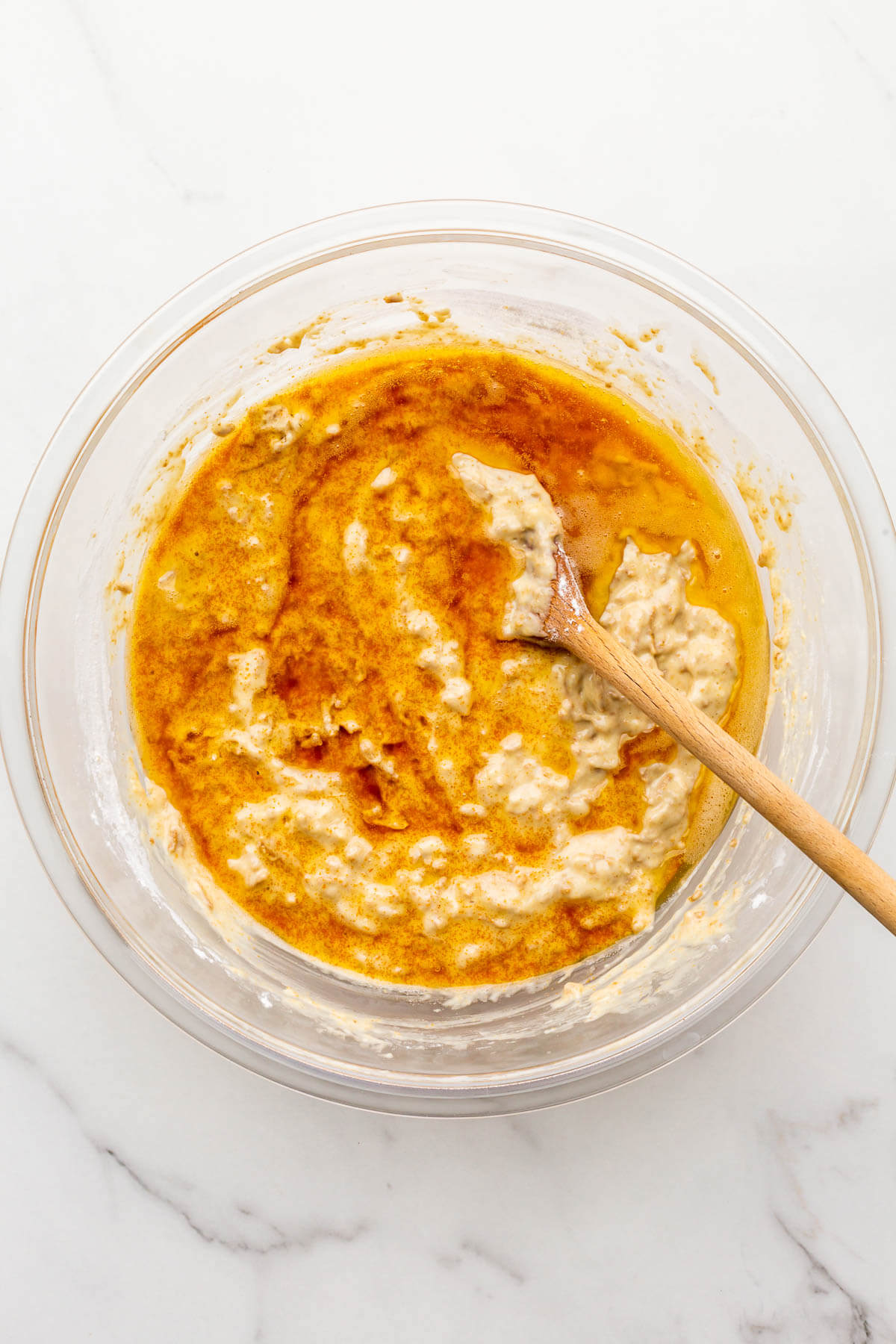 Stirring browned butter into muffin batter to make bran muffins.