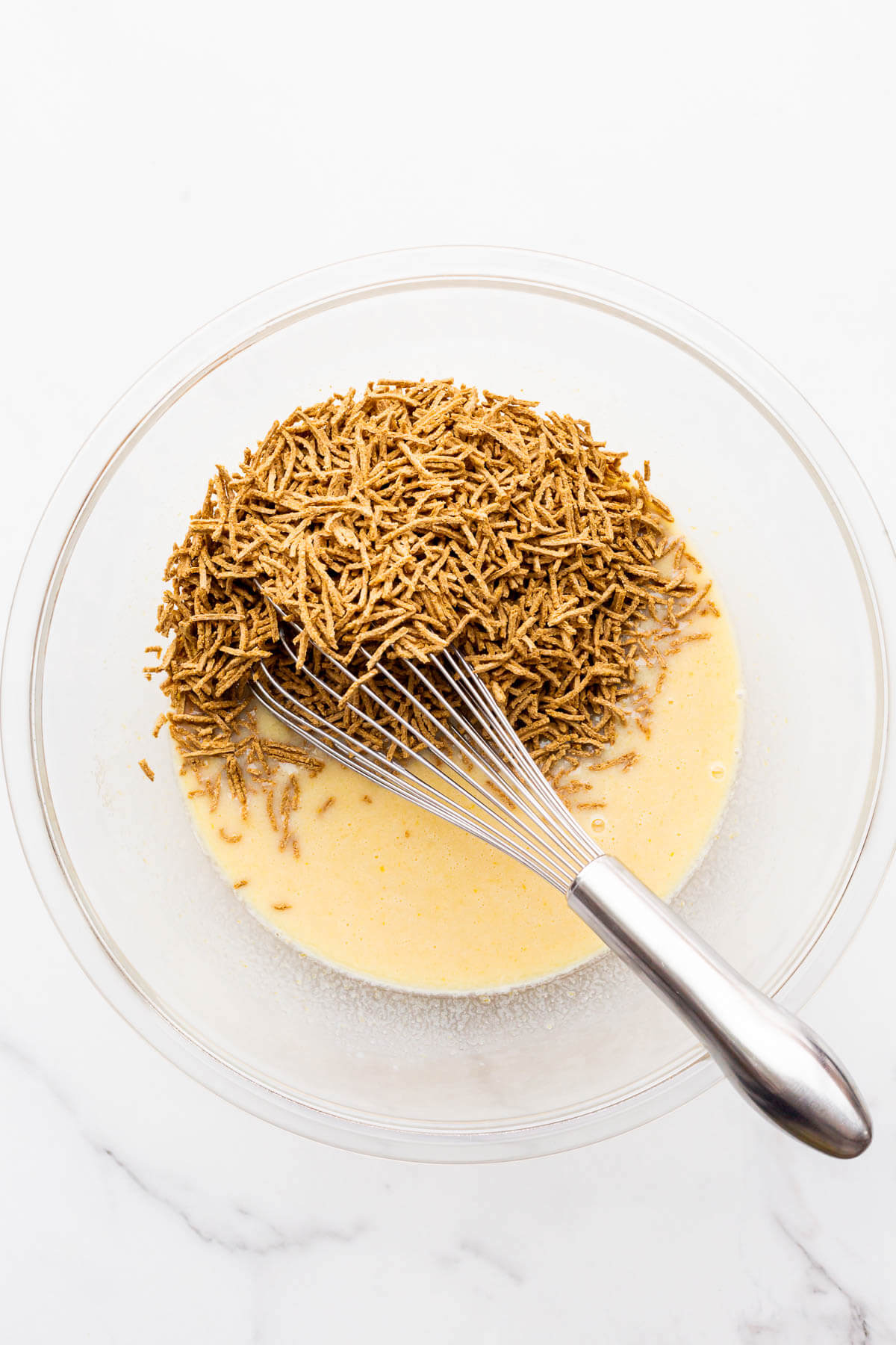 Stirring All-Bran cereal into the wet ingredients to make date bran muffins.