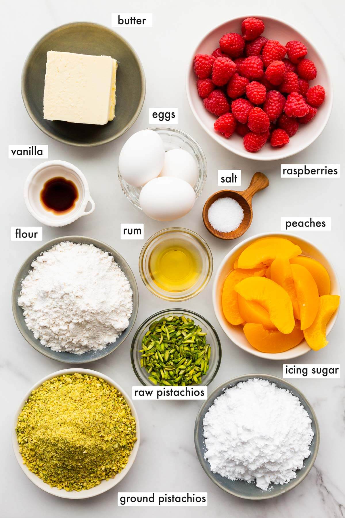 Ingredients to make a pistachio tart from scratch that you will top with fruits (such as sliced peaches and raspberries, pictured in this photo).