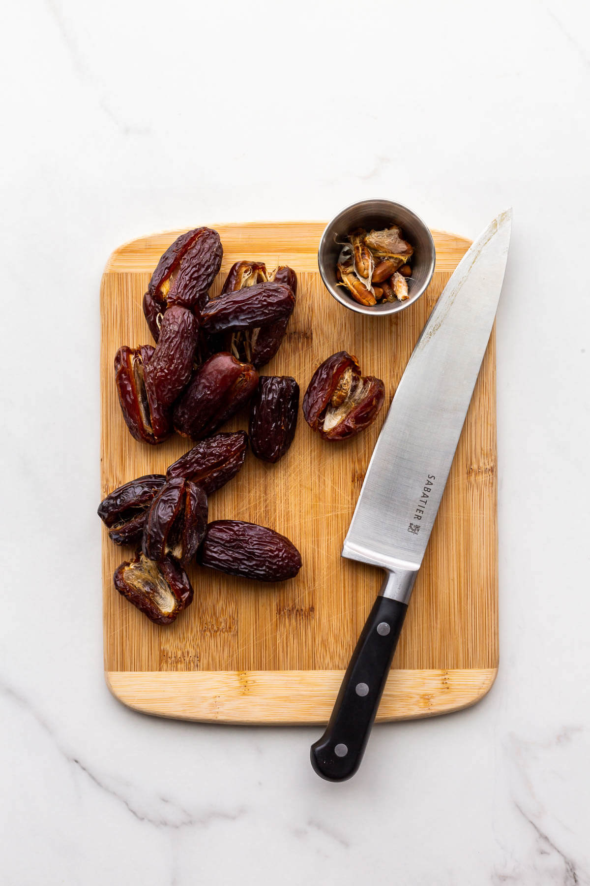 Pitting Medjool dates on a wood cutting board to incoporate them in bran muffins.