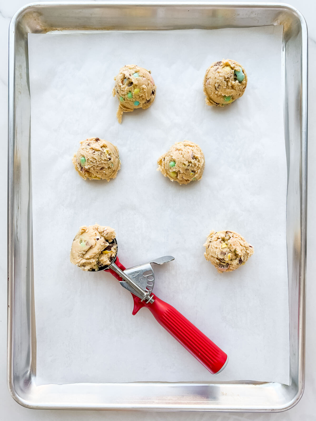 https://bakeschool.com/wp-content/uploads/2023/03/Scoop-dough-onto-parchment-lined-sheet-pan.jpg