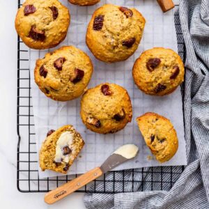 Serving freshly baked date bran muffins with butter for breakfast on a cooling rack.