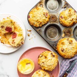 Serving rhubarb muffins on plates with a side of butter.