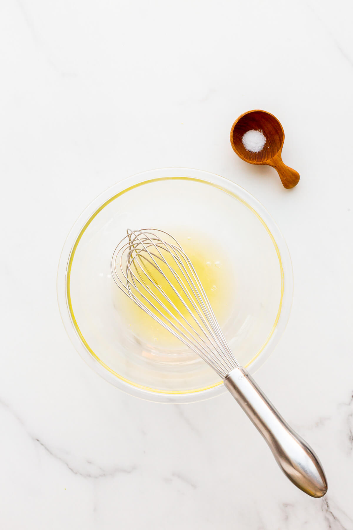 Egg whites in a bowl with salt to make whipping them by hand with a whisk easier