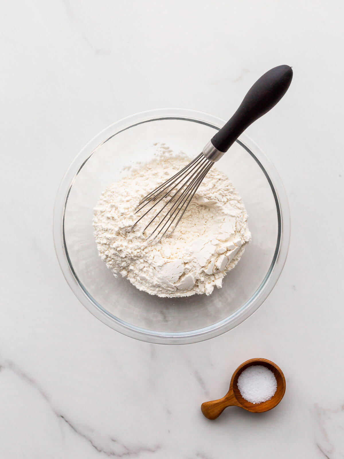 Whisking flour and salt in a small bowl to make a pistachio tart crust.