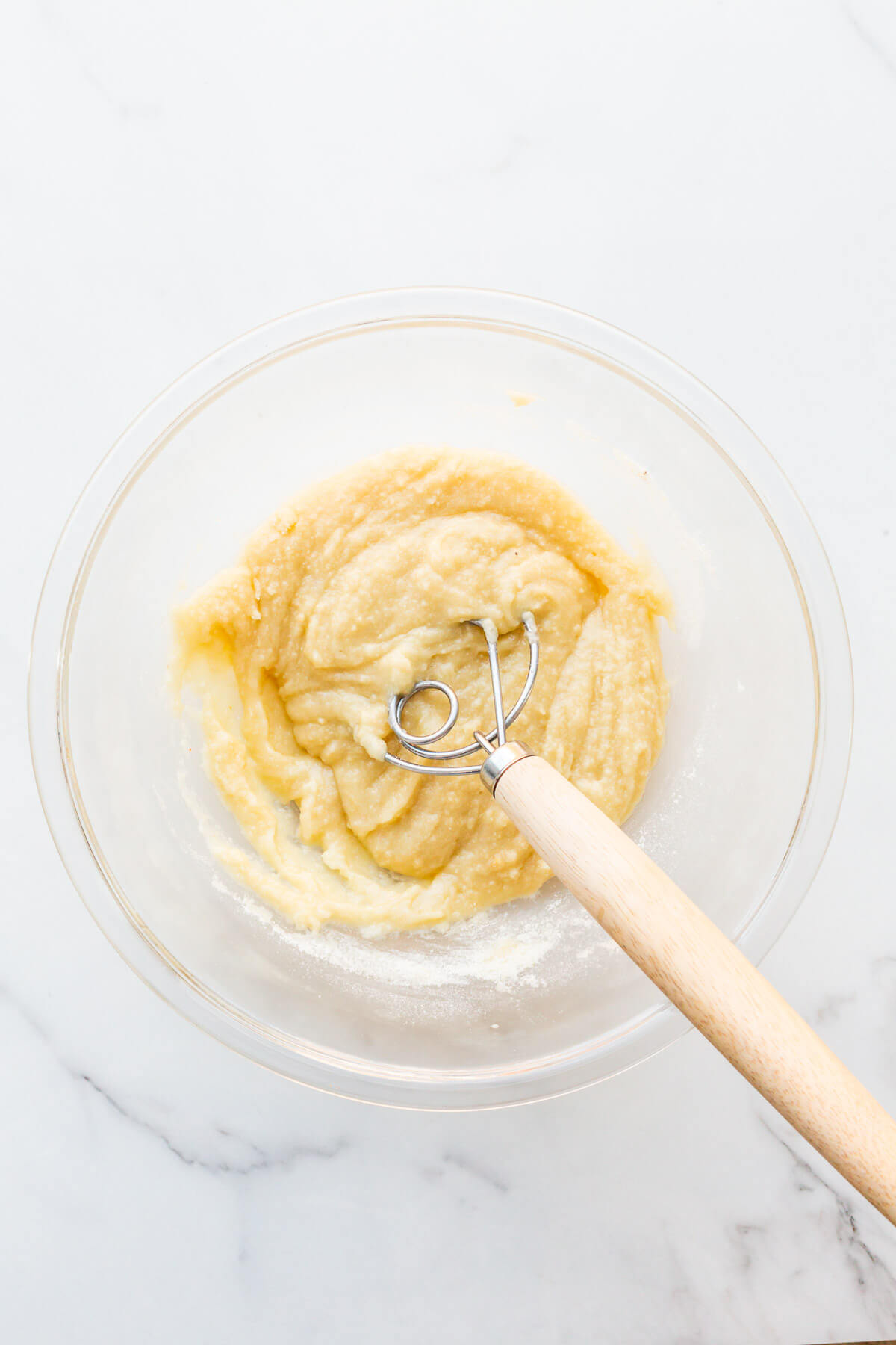 Almond financier batter in a glass bowl before adding brown butter.