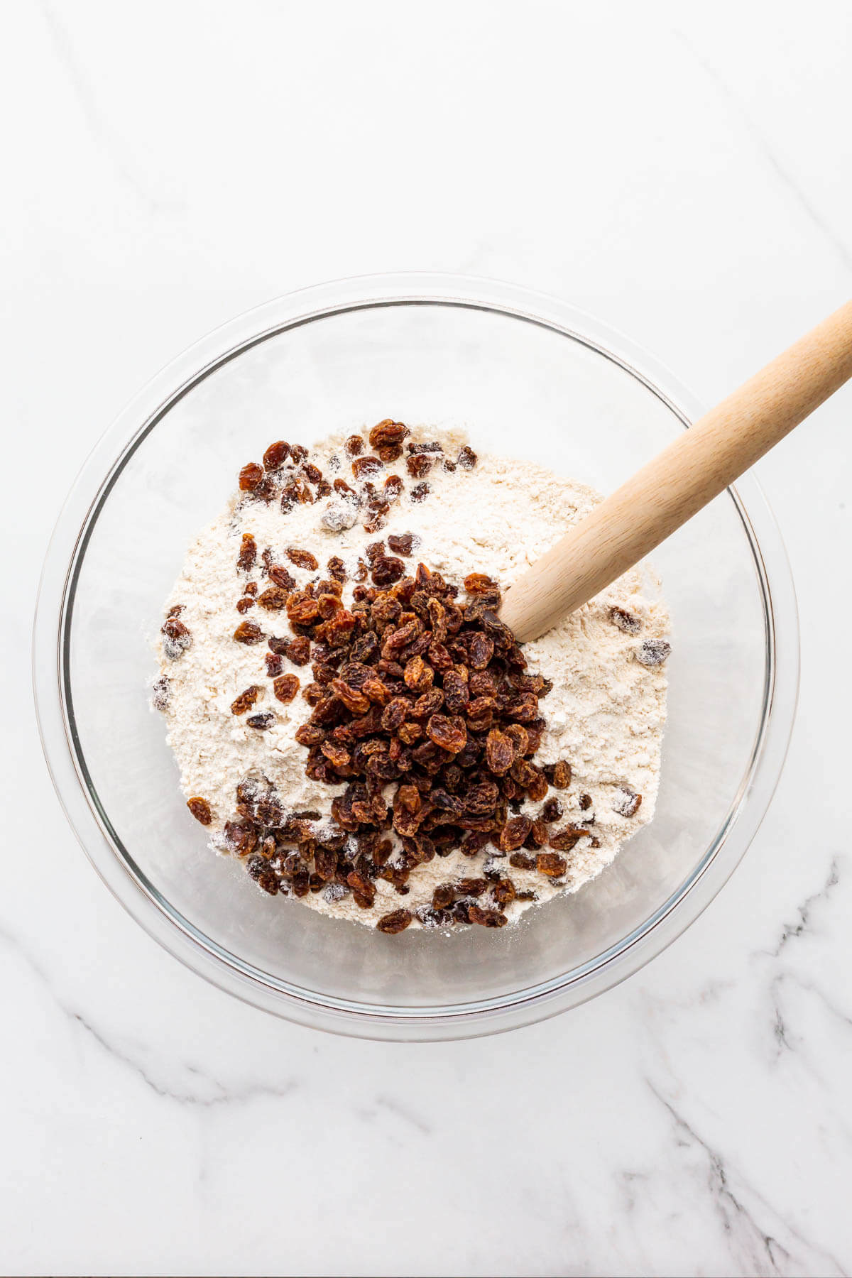 Whisking dry ingredients with raisins to make soda bread.