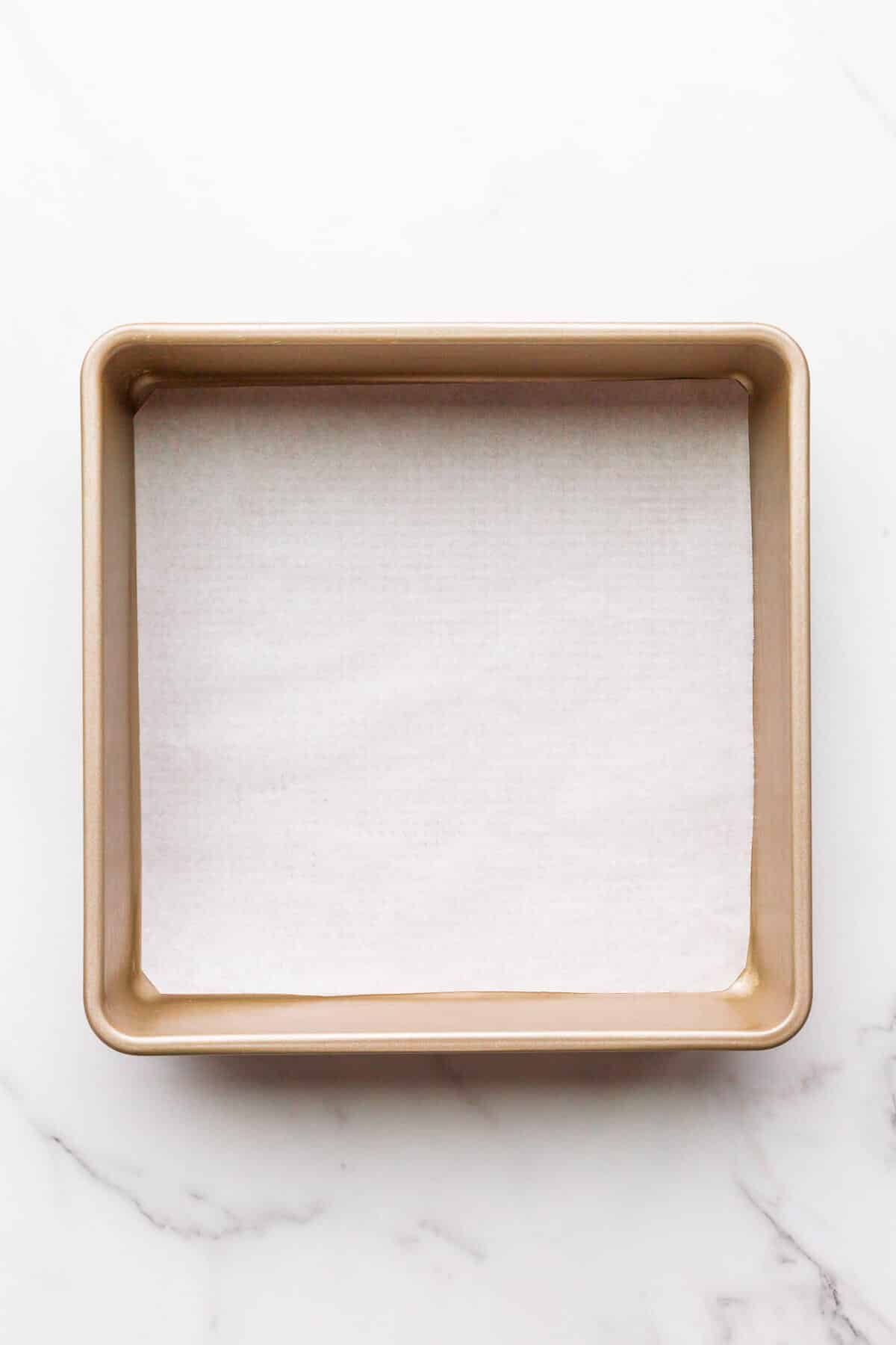 Buttered 9x9 square cake pan lined with a square of parchment paper fitted to the bottom of the pan to prevent cakes from sticking.