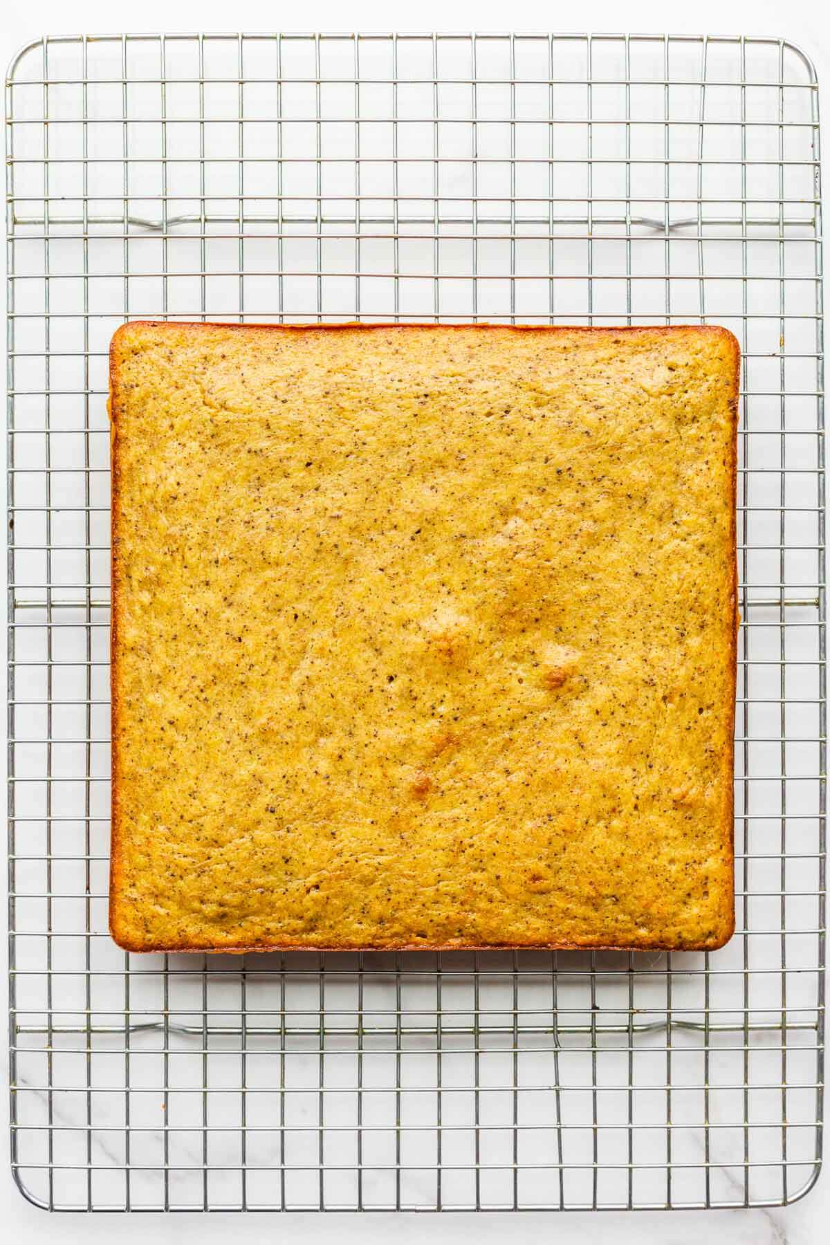 A square banana snack cake on a cooling rack.