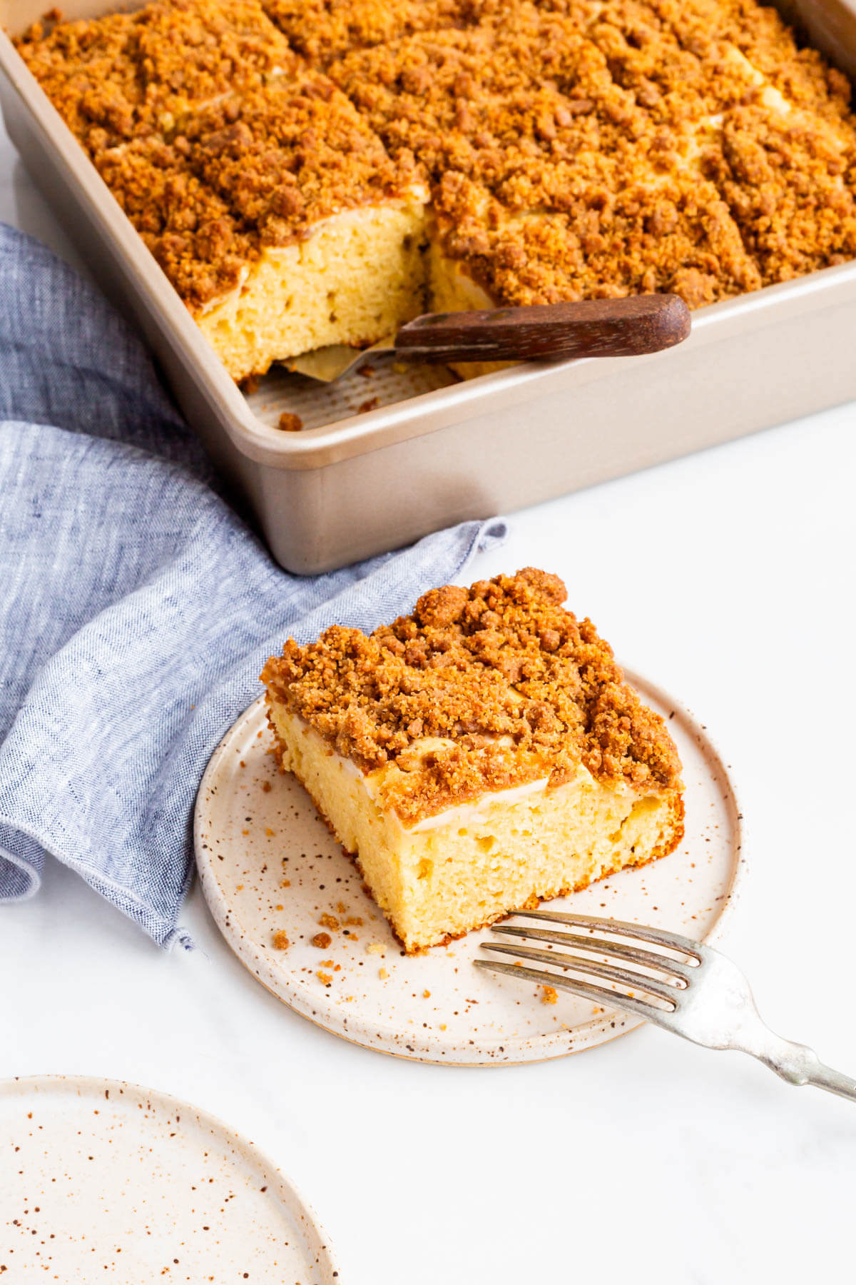 Apple coffee cake served on a dessert plate with a fork.