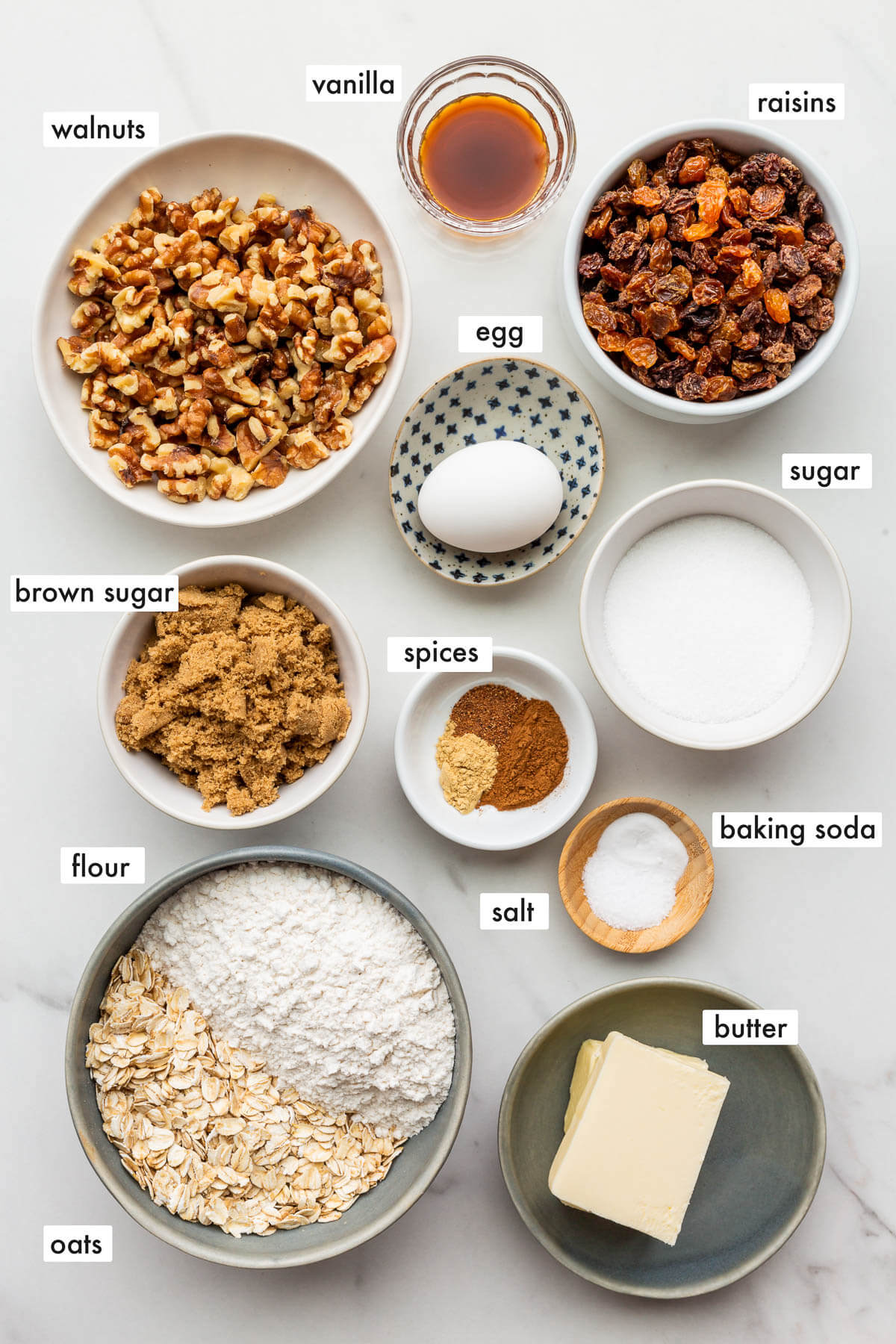 Ingredients to make oatmeal raisin cookies with walnuts laid out and ready to bake with.