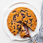 Slicing a blueberry crumb cake.