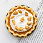 Sweet potato pie topped with whipped cream and grated nutmeg.