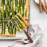 Serving an asparagus phyllo tart cut into squares.