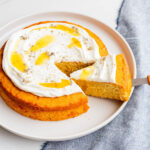 Slicing and serving a honey cake with whipped cream and lavender on top.