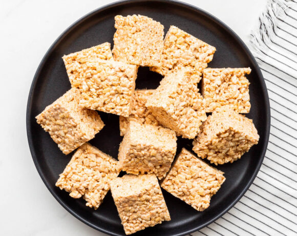 A plate of puffed rice and marshmallow treats cut into squares.