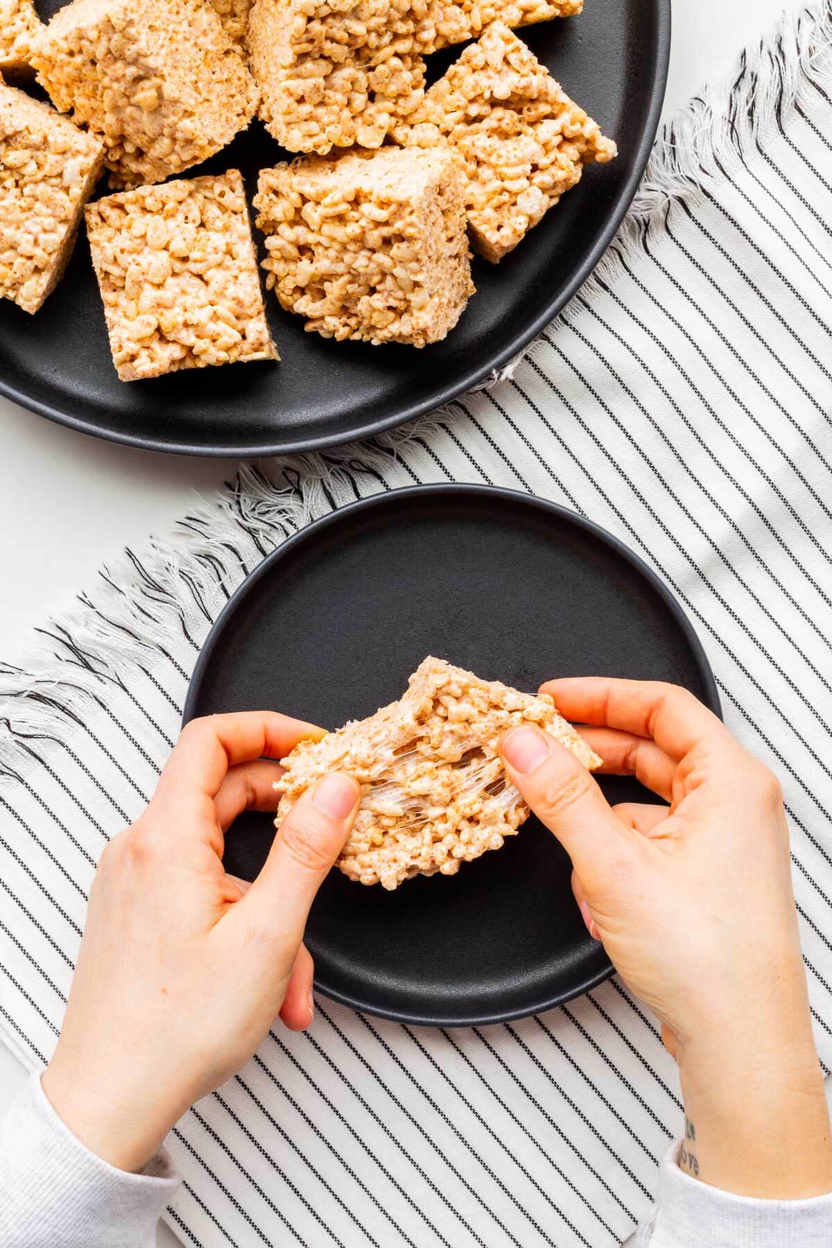 Tearing apart a puffed rice treat to show how gooey it is.
