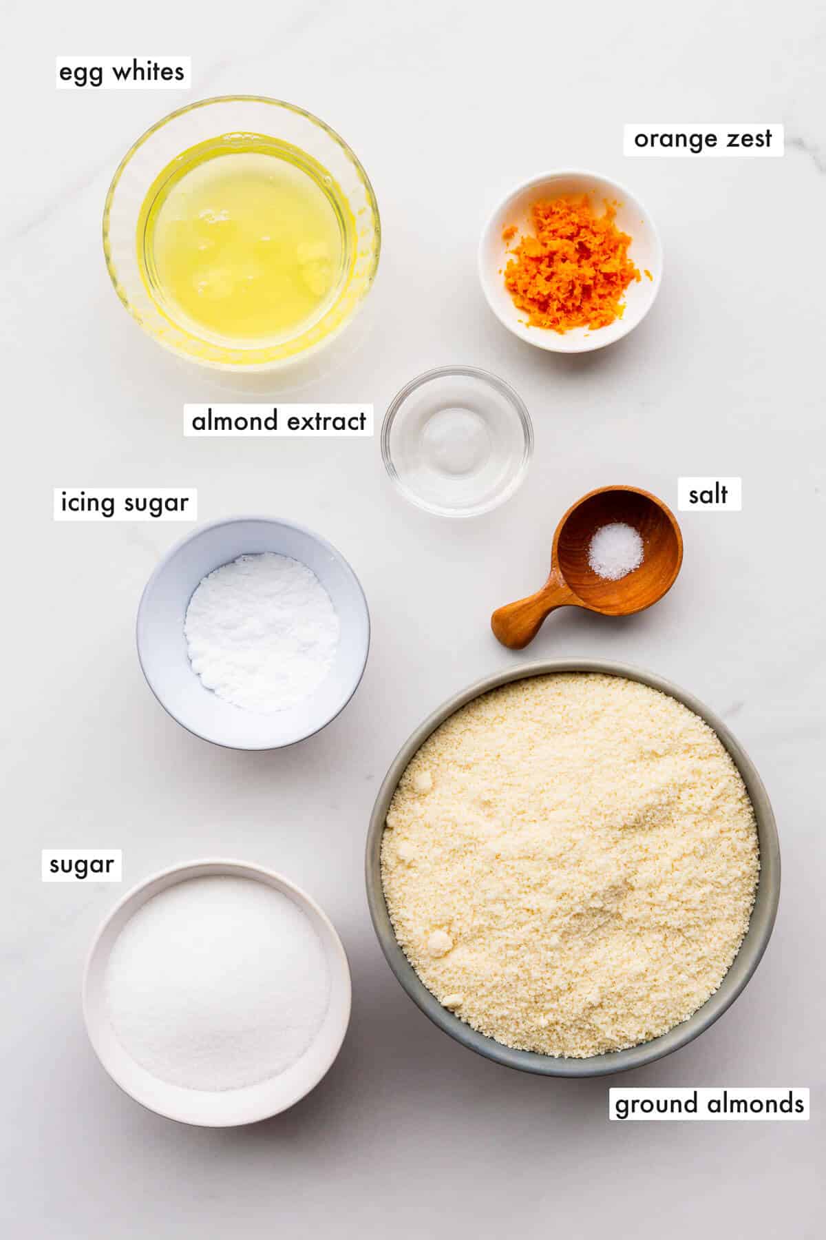 Ingredients to make amaretti cookies measured out into small bowls.