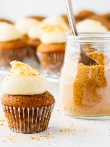 Apple cupcakes with cream cheese frosting on top and graham cracker crumbs.