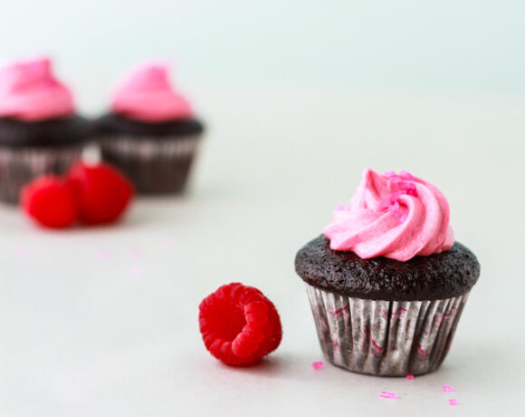 A dark chocolate cupcake with pink frosting swirl.