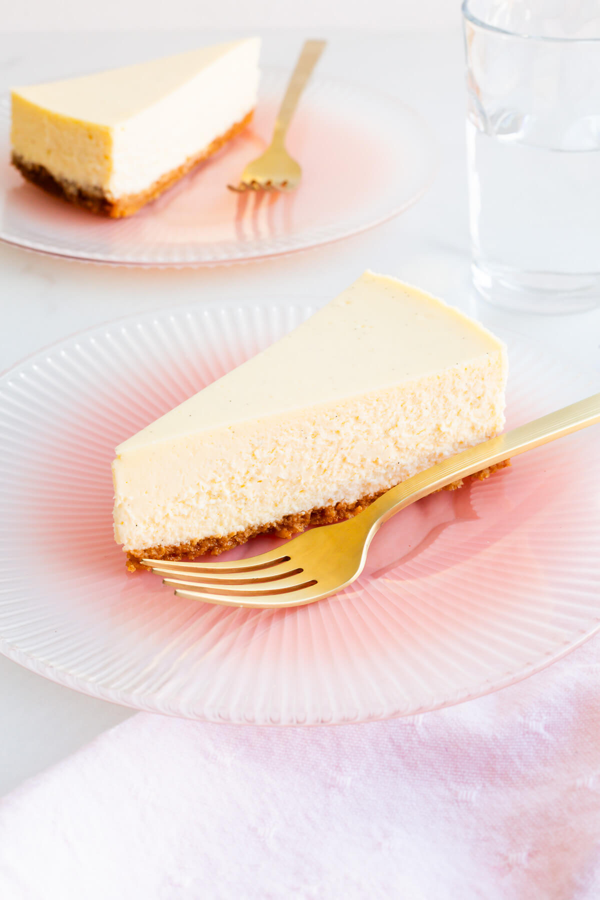 Slices of perfect baked cheesecake on dessert plates.