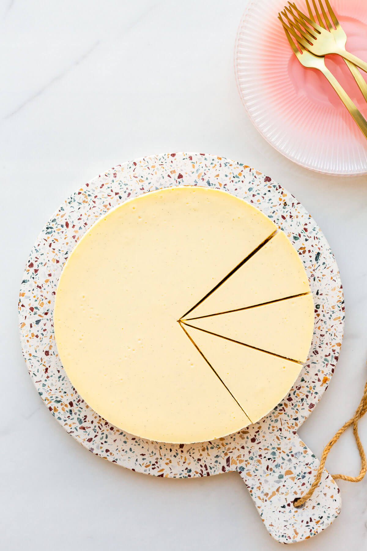 A baked cheesecake sliced into pieces to serve it.