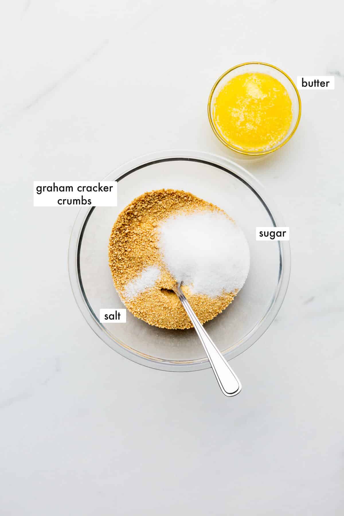 Ingredients to make a graham cracker crust measured out in a bowl, ready to be mixed.