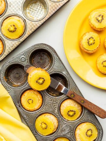 Serving coconut cakes topped with golden kiwi fruit slices