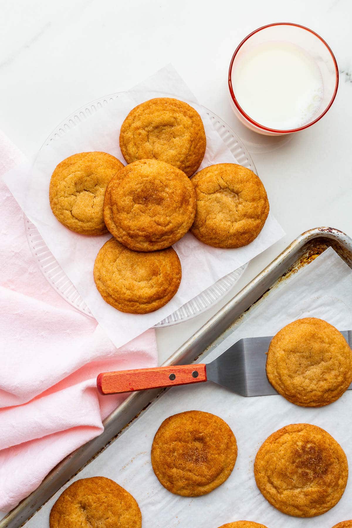 Transferring freshly-baked homemade snickerdoodles to a plate to serve them.