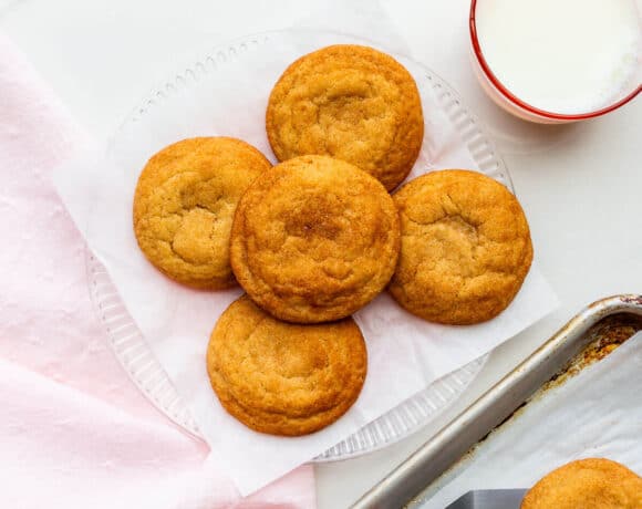 A plate of freshly-baked homemade snickerdoodles transferred from the cookie sheet with a spatula.