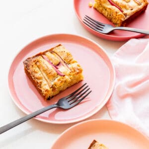 Slices of moist rhubarb cake served on plates.